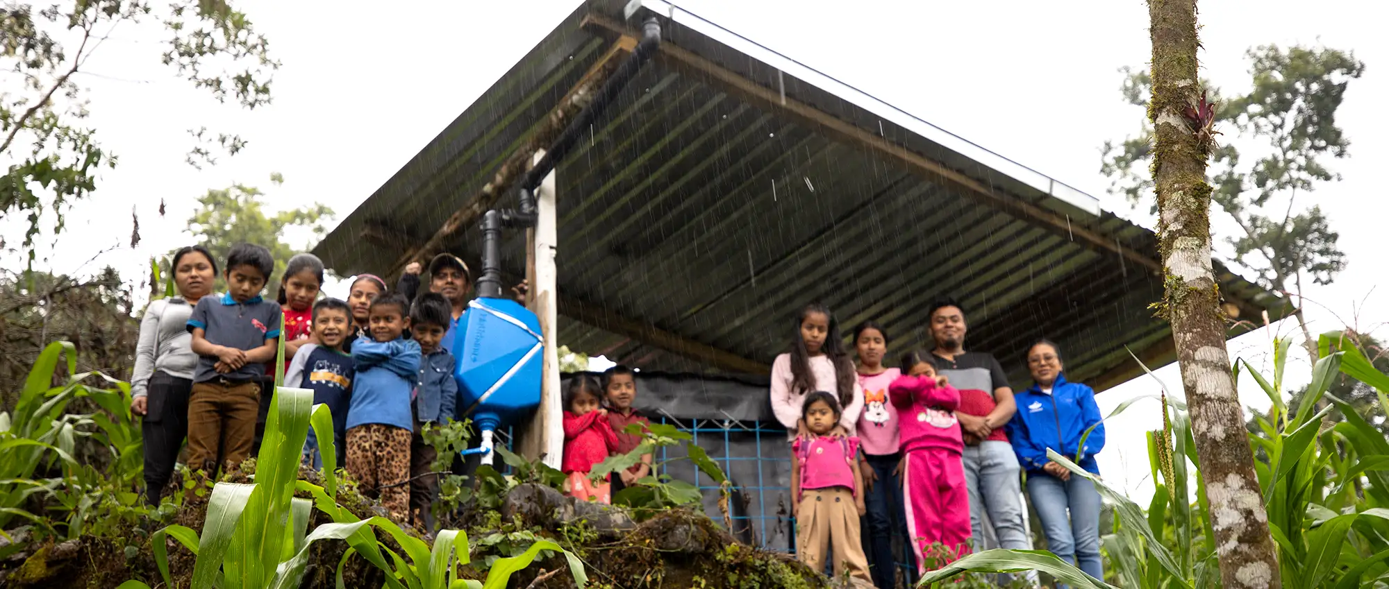 Agua Vida-Mazateca SCALL Agua Vida. A family reunited next to their rainwater harvesting system while is raining in the Sierra Mazateca in Oaxaca, Mexico.